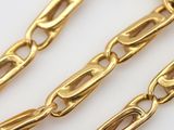 a close up of a gold chain on a white surface