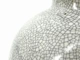 a white vase that has a cracky design on it