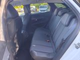the back seats of a white car are empty in a parking lot
