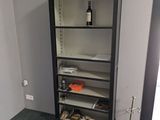 une bibliothèque noire sur laquelle est posée une bouteille de vin