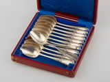 six silver spoons in a red case on a white surface