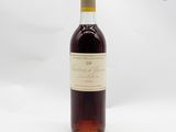 une bouteille de vin rouge posée sur une table blanche