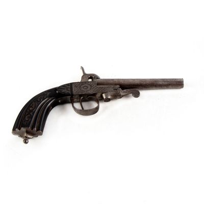 un vieux pistolet posé sur une surface blanche