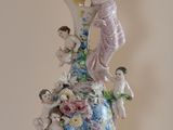 a vase with a figurine of a woman and children on it