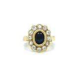 a close up of a gold ring with a sapphire and diamonds