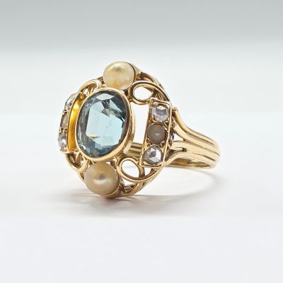 une image représentant une bague en or sertie d'une topaze bleue et de perles