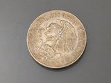 an image of a coin with a eagle on it on a gray surface