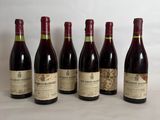 six bottles of wine are lined up on a table