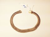 a close up of a gold chain bracelet with a tag on it