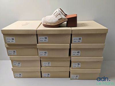 une pile de cartons sur laquelle est posée une paire de chaussures