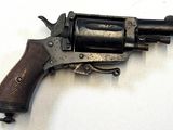 un petit revolver posé sur une surface blanche