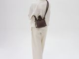 a woman in a white shirt and white pants stands with her back to the camera