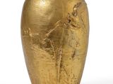 a gold vase with a horse on it on a white surface