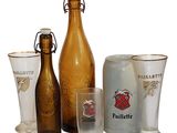 des bouteilles et des verres sont alignés les uns à côté des autres sur une surface blanche