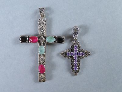 deux pendentifs en forme de croix ornés de pierres multicolores sur un fond blanc