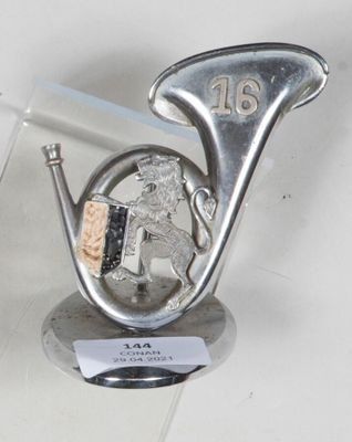 a silver sculpture of a man playing a musical instrument