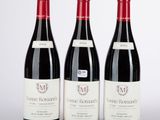 trois bouteilles de vin rouge posées sur une table blanche