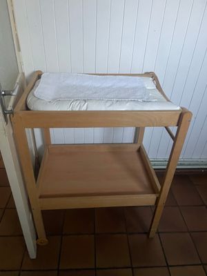 une petite table en bois sur laquelle est posé un lit de bébé