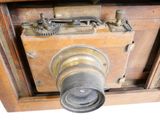 an old wooden camera with a lens attached to it