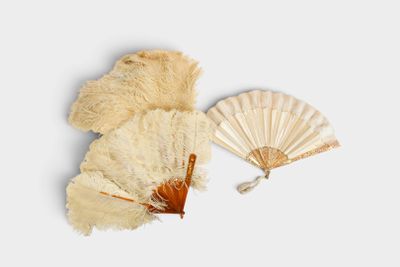 a white fan and a brown fan on a white surface