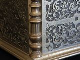 a silver box with a design on it on a black surface