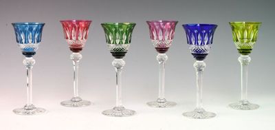 several different colored wine glasses are lined up in a row