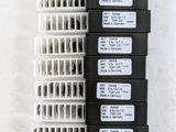 three rows of white and black plastic boxes with labels on them