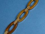 a close up of a bracelet with a chain on a blue surface