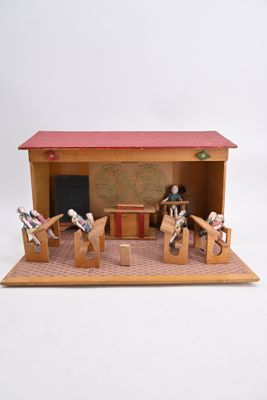 a small wooden model of a classroom with a desk and chairs