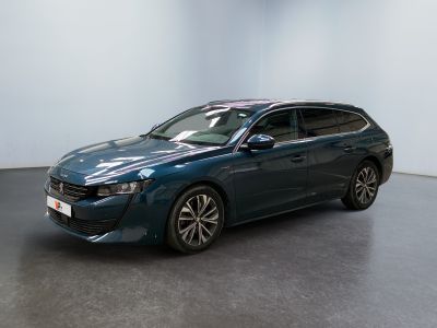 La voiture bleue est garée dans une grande pièce au sol noir.