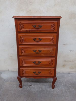 an image of a wooden chest of drawers against a wall