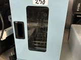 un four bleu posé sur une table, avec une pancarte en noir et blanc