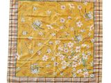 a close up of a yellow handkerchief with flowers on it