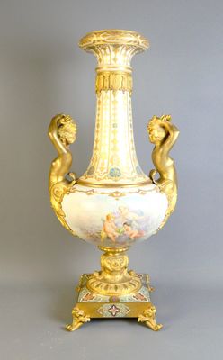 a gold vase with two cherns on it on a stand