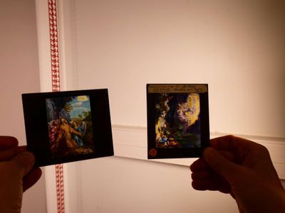 deux personnes tenant des photos d'un tableau dans une pièce