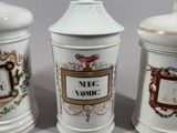 three white ceramic containers with decorative designs on them sitting on a table