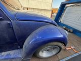 a blue car that is being unloaded by a truck