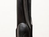 a black sculpture on a white pedestal with a white background