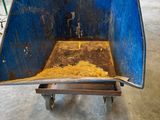 a blue wheelbarrow that is filled with dirt