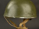 a green helmet on a clear stand against a black background