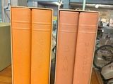 three books that are sitting on a wooden table