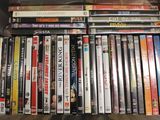 beaucoup de DVD rangés sur une étagère, dans une boîte
