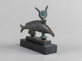 un gros plan d'une statue représentant un animal posée sur un socle noir