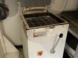 a man standing next to a stove in a kitchen