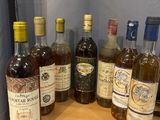 several bottles of wine are lined up on a wooden table