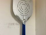 a blue spatula hanging on the wall of a bathroom