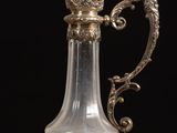 a glass vase with a bird on it sitting on a table