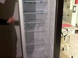 un homme debout à côté d'un réfrigérateur ouvert dans une cuisine
