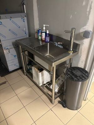 a kitchen with a sink and a trash can in it