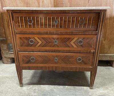 a wooden chest of drawers with marble top and drawers